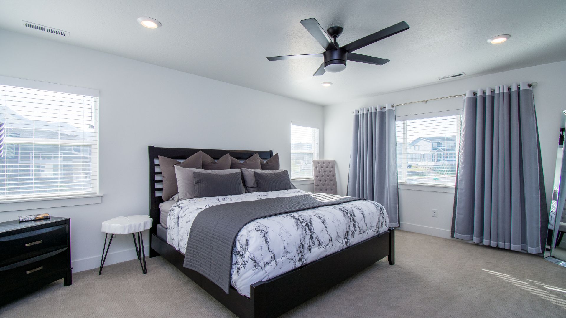 A bedroom with a large bed and a ceiling fan